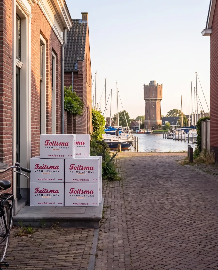 Watertoren van Aalsmeer aan de Westeinderplassen op een zonnige dag met verhuisdozen bij een voordeur