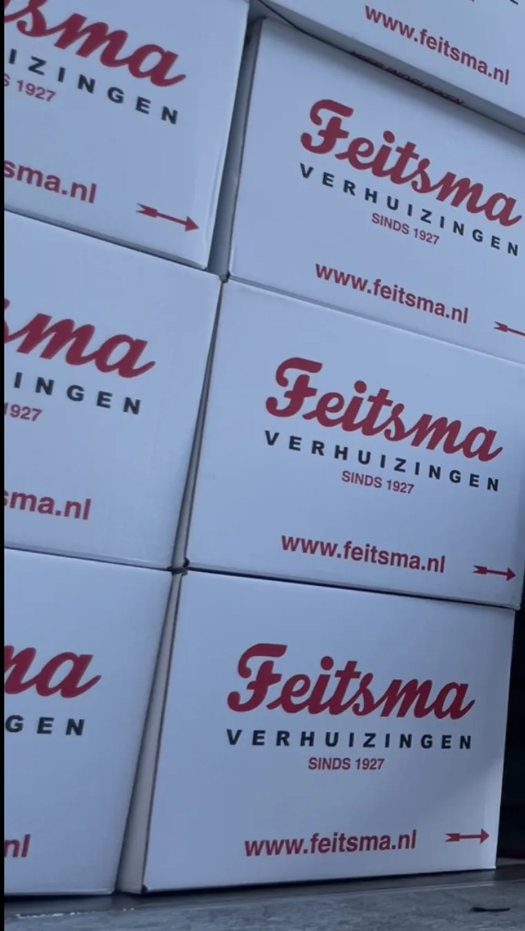 Stacked moving boxes printed with the Feitsma Verhuizingen logo and the line sinds 1927, Dutch for since 1927