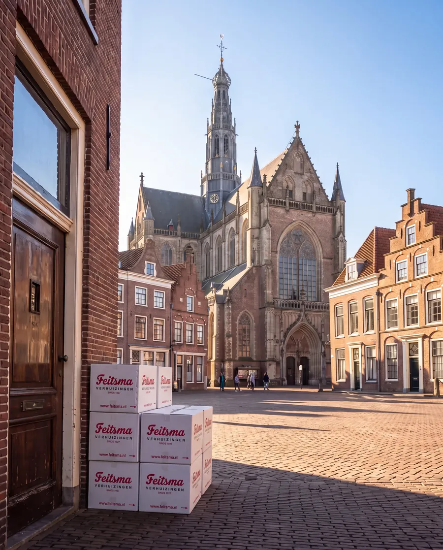 Verhuisdozen van Feitsma op de Grote Markt in Haarlem, met de Grote of Sint-Bavokerk erachter