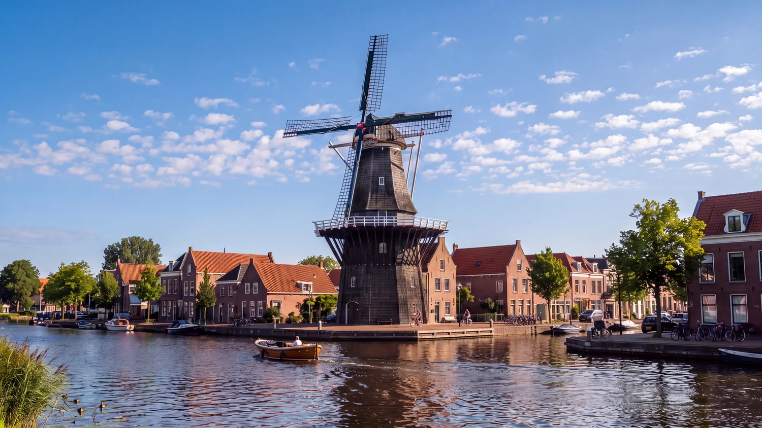 Windmill De Adriaan on the river Spaarne in Haarlem, with a small boat on the water
