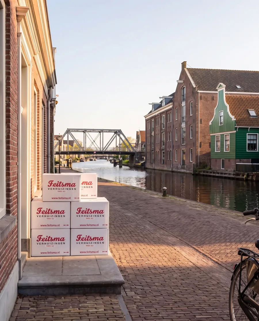 Pakhuizen aan de Zaan bij de Zaanbocht in Wormerveer op een zonnige dag met verhuisdozen bij een voordeur